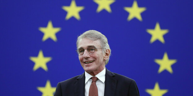David Sassoli steht vor blauen Wand mit EU-Sternen