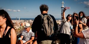 Touristen machen Selfies vor der Skyline von barcelona