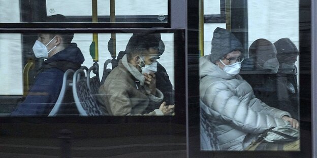 Fahrgäste mit Mundschutzmasken in einem Bus der BVG