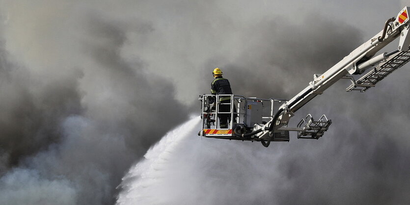 Dichte Rauchwolken und ein Feuerwehrmann