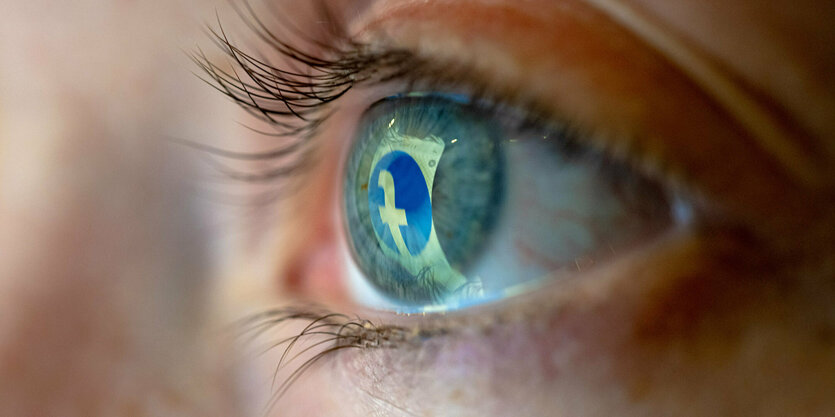 Das Facebook-Logo spiegelt sich in einem Auge