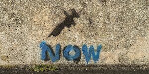 Eine Graffiti zeigt eine Spritze und das Wort "Now"