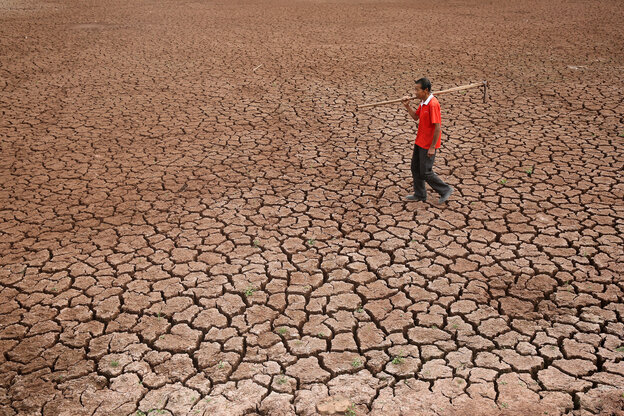Ein Farmer läuft über sein ausgedörrtes Feld im Südwesten von China Ein Farmer läuft über sein ausgedörrtes Feld im Südwesten von China