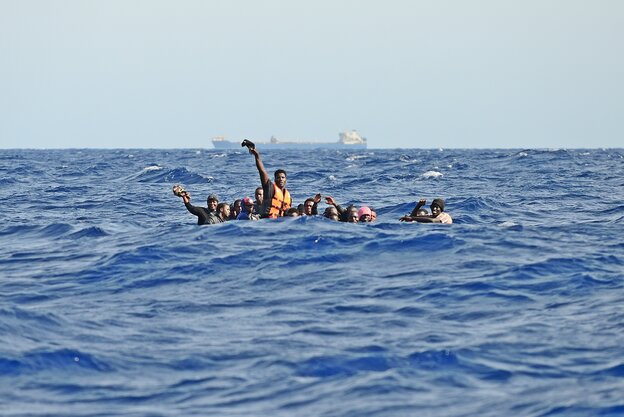Eine Gruppe Menschen sitzt dicht gedrängt in einem Boot auf dem Mittelmeer Eine Gruppe Menschen sitzt dicht gedrängt in einem Boot auf dem Mittelmeer
