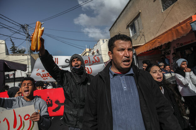 Ein Demonstrant in Tunis hält ein zerbrochenes Baguette in die Höhe Ein Demonstrant in Tunis hält ein zerbrochenes Baguette in die Höhe