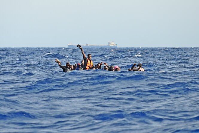 Eine Gruppe Menschen sitzt dicht gedrängt in einem Boot auf dem Mittelmeer