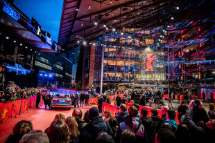 Menschen warten am roten Teppich der Berlinale