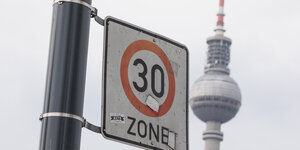 Im Vordergrund ist ein Schild mit Tempo 30 Zone zu sehen. Im Hintergrund sieht man den Berliner Fernsehturm.