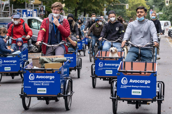 Mehrere Menschen demonstrieren mit einem Lastenrad durch die Straße