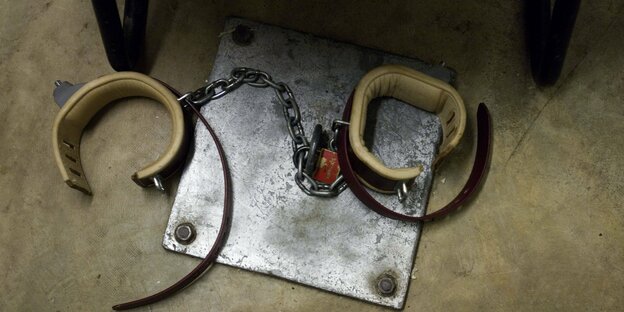 Beinfesseln eines Häftlings in einem Befragungsraum liegen geöffnet auf einer Metallplatte