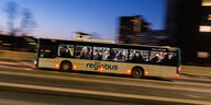 Ein Regiobus fährt durch die Abenddämmerung.