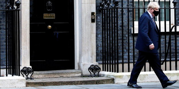 Boris Johnson läuft mit Mund/Nasenschutz den Bürgersteig der Downing Street entlang