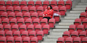 Ein Zuschuerin sitzt im Stadion.