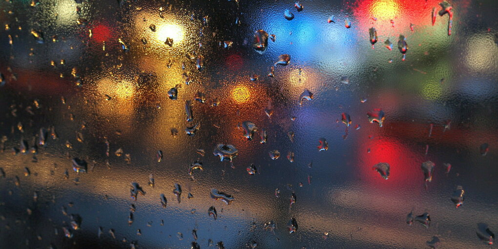 Lichter durch eine regennasse Fensterscheibe