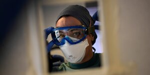 Eine medizinische Mitarbeiterin setzt sich in der Intensivstation der «Clinica Universitaria» eine Schutzbrille auf.