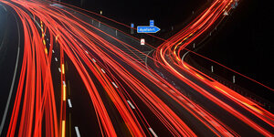 Die Langzeitbelichtung zeigt Leuchtspuren von PKW und LKW auf der Autobahn