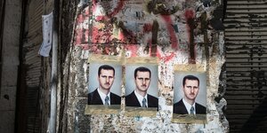 Plakate mit dem Konterfei von Baschar al Assad sind auf eine Hauswand geklebt