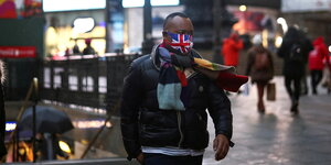 Ein Mann trägt eine Maske in den Farben der britischen Flagge