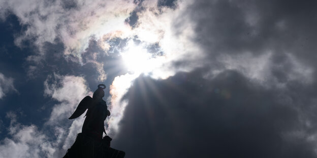 Sonne und dunkle Wolken erscheinen am Himmel über der Statue der römischen Göttin Concordia