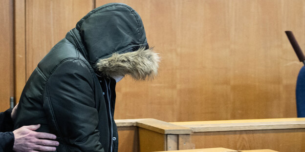 Der Angeklagte verstekt sein Gesicht hinter einer Kapuze