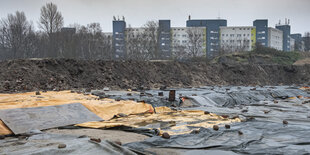 Abgedeckte Plastikplanen liegen vor den Hochhäusern von Bremen-Oslebshausen