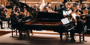 Die Pianisten des GrauSchumacher Piano Duo vor Musikern des DSO auf der Bühne des Großen Sendesaals im Haus der Rundfunks.
