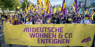 Menschen auf einer Demonstration tragen ein Banner von Deutsche Wohnen und Co. enteignen