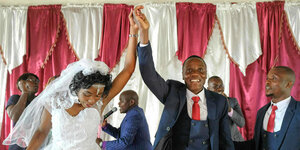 Ein Brautpaar mit erhobenen Händen