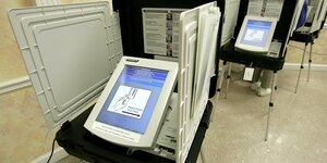 Wahlmaschinen in hintereinander stehenden Wahlkabinen