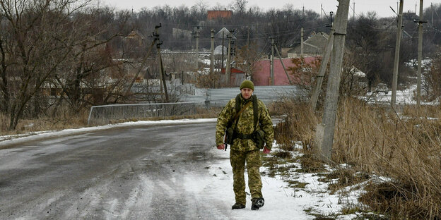 Ein Soldat läuft an einer verschneiten Landstraße
