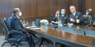 Männer in Uniformen sitzen an einem Konferenztisch