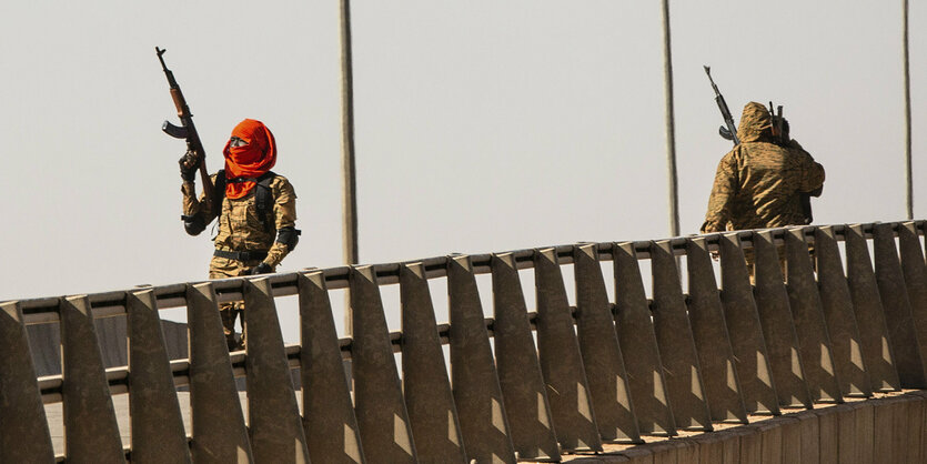 Soldaten stehen auf einer Straßenbrücke.