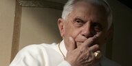 Papst Benedikt XVI. hält sich die Hand vor den Mund, er trägt einen großen goldring