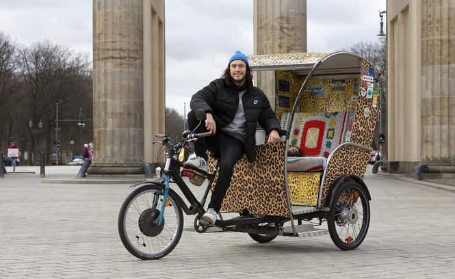 Eine Rikscha-Fahrer vor dem Brandenburger Tor