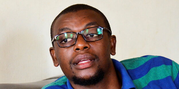 Kakwenza Rukirabashaija mit Brille und einem geringelten Shirt