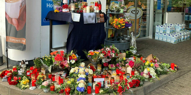 Blumen und kerzen als Trauerzeichen für den erschossenen Mitarbeiter vor der Tankstelle