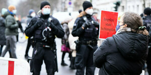 Eine Demonstrantin hält ein Schild mit der Aufschrift "Impfen statt Schimpfen!"