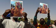 Zwei Männer hlaten Fotos des Militärchefs aus Burkina Faso in die Höhe