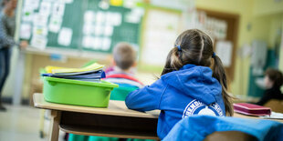 Kinder sitzen mit Abstand in einem Klassenzimmer