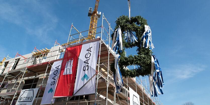 Ein Richtkranz hängt vor einem Neubau