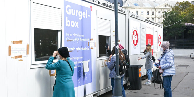 Teststation im Container mit einigen Frauen davor