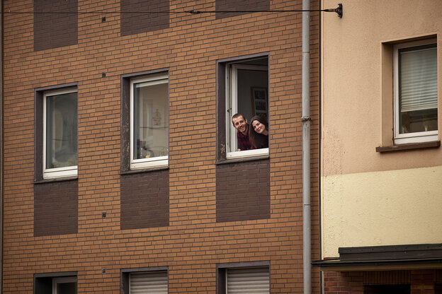 Zwei Menschen schauen aus einem Fenster.