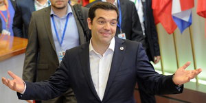 Alexis Tsipras lächelt mit ausgebreiteten Armen