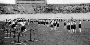 Frauenriegen formieren sich im Stadion vor den Barren