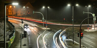 Straßenbeleuchtung, Häuser und langgezogene Lichtspuren von Verkehr