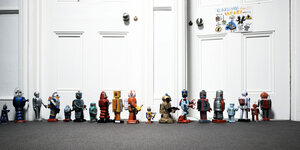 Roboter Spielzeug in einer Reihe vor verschlossenen Türen