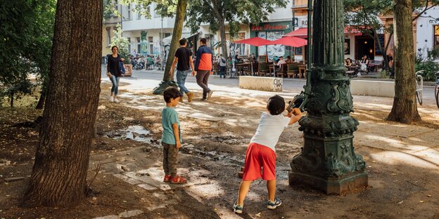 Kinder spielen am Lausitzer Platz in Berlin an der Fahrbahn, die durch sogenannte "Kiezblöcke" für Autos blockiert ist.