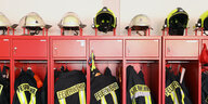 Ein Schrank mit Jacken und Helmen der Freiwilligen Feuerwehr steht in einem Gebäude.