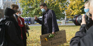 Habeck im Freien mit Aktivist:innen, die ihm eine Sonnenblume und eine Forderung auf einem Pappschild überreicht haben