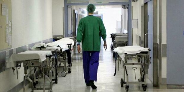 Ein Pfleger läuft einen Krankenhausflur entlang